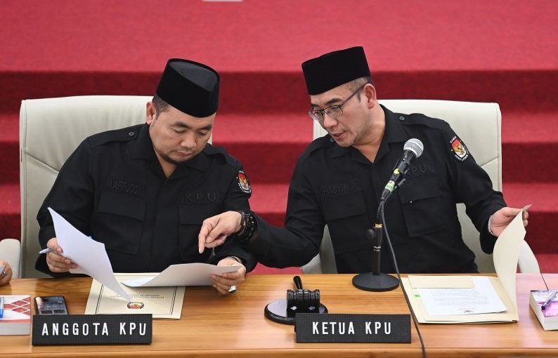Ketua Komisi Pemilihan Umum (KPU) Hasyim Asy'ari (kanan) berbicara dengan Komisioner KPU Mochammad Afifuddin (kiri) di sela rapat pleno penetapan hasil penghitungan perolehan suara Pemilu 2024 tingkat nasional di Gedung KPU, Jakarta, Rabu (20/3/2024). Fot