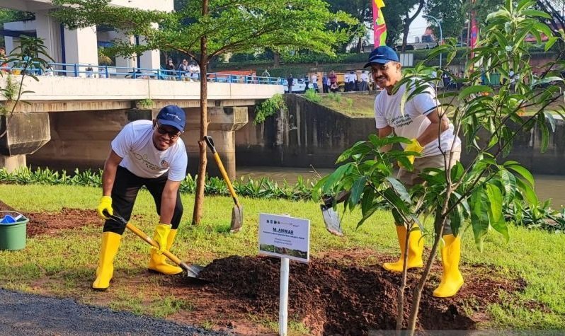 Wali Kota Administrasi Jakarta Timur M Anwar (kanan) bersama Direktur Pengembangan Usaha PT Antam Tbk I Dewa Wirantaya saat melakukan penanaman pohon produktif di bantaran kali di Pintu Air Kanal Banjir Timur (KBT), Kelurahan Malaka Sari, Kecamatan Duren 