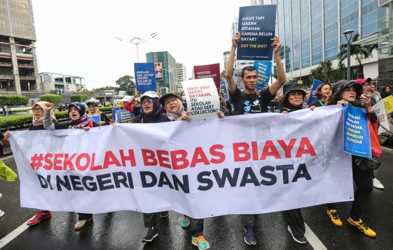 Sejumlah aktivis dari Jaringan Pemantau Pendidikan Indonesia berjalan sambil membentangkan spanduk dan poster saat aksi pada Hari Bebas Kendaraan Bermotor (HBKB), di kawasan Bundaran HI, Jakarta, Minggu (7/7/2024). Foto: ANTARA