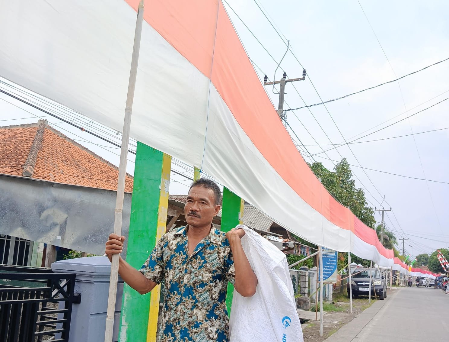 Rosadi (54) seorang kuli bangunan asal Cianjur, bentangkan bendera panjang 450 meter. Foto: apakabar.co.id/ Riski M