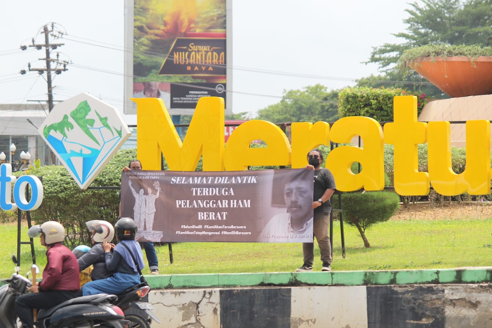 Dua orang masyarakat sipil melakukan aksi simbolik di Bundaran Simpang Empat Kota Banjarbaru, Kalimantan Selatan, Minggu (20/10). 