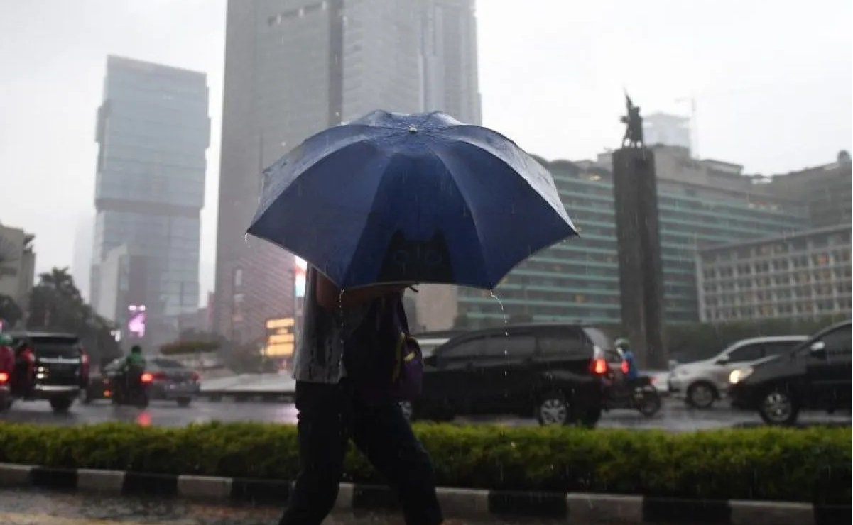 Arsip Foto. Warga menggunakan payung untuk menghindari hujan saat melewati kawasan Bundaran Hotel Indonesia, Jakarta. Foto: ANTARA
