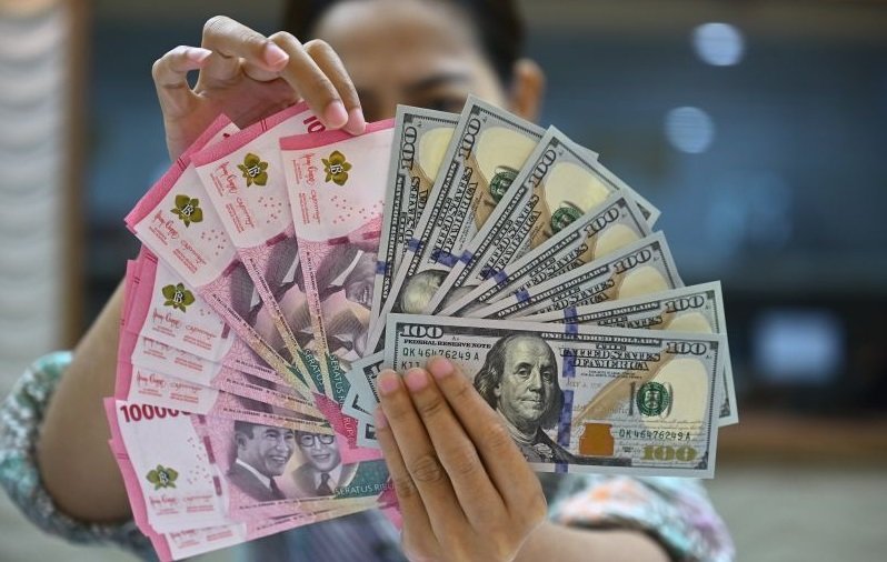 Petugas menjunjukkan uang pecahan dolar AS dan rupiah di gerai penukaran mata uang asing di Jakarta, Jumat (2/1/2025). Nilai tukar rupiah terhadap dolar AS pada perdagangan Jumat ditutup menguat 1 poin atau 0,01 persen menjadi Rp16.197 per dolar AS didoro
