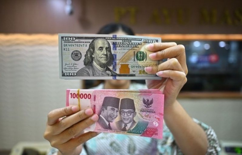 Ilustrasi - Petugas menjunjukkan uang pecahan dolar AS dan rupiah di gerai penukaran mata uang asing di Jakarta. Foto: ANTARA