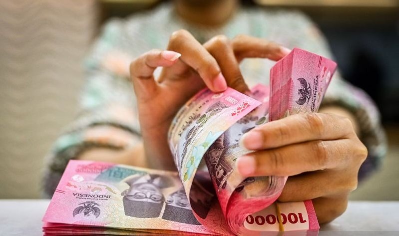 Petugas menghitung uang pecahan dolar AS dan rupiah di gerai penukaran mata uang asing di Jakarta. Foto: ANTARA