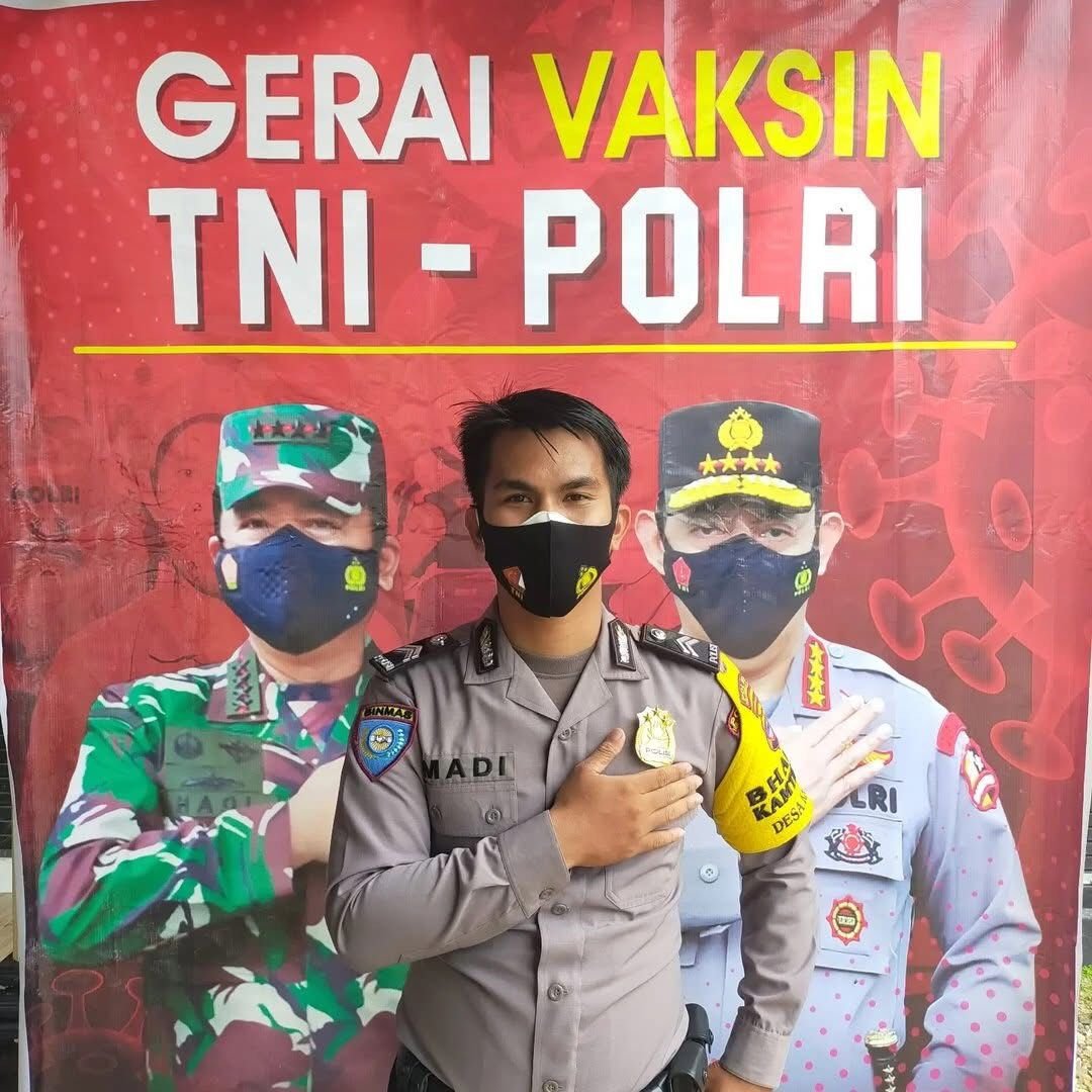 Seorang polisi tengah mensosialisasikan vaksin. Foto: ilustrasi